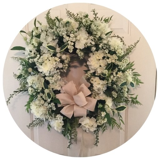 A cream hydrangea wreath that is complimented by Queen Anne's Lace and snowball flowers.